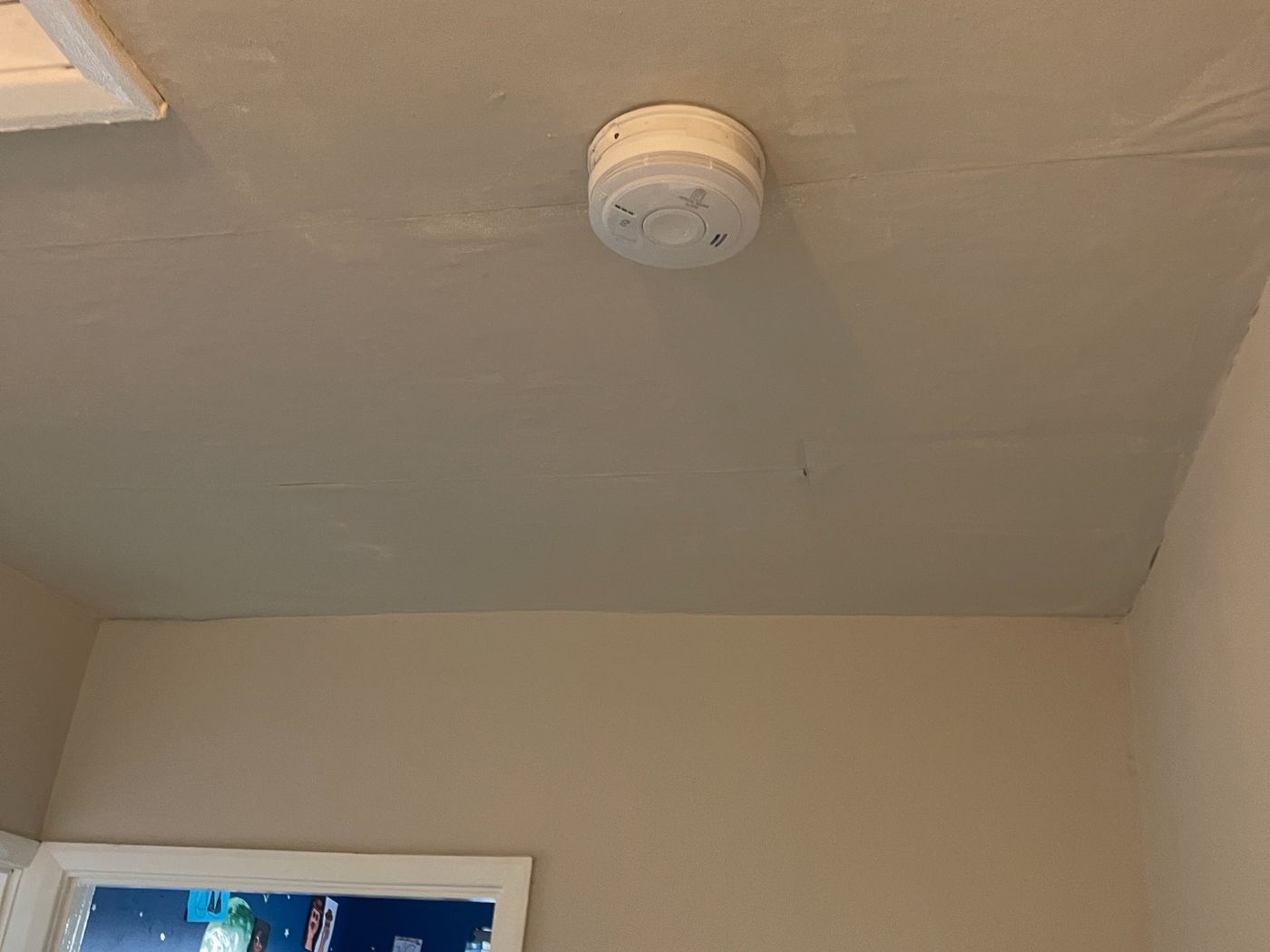 Mains-wired smoke alarm detector fitted to a landing ceiling